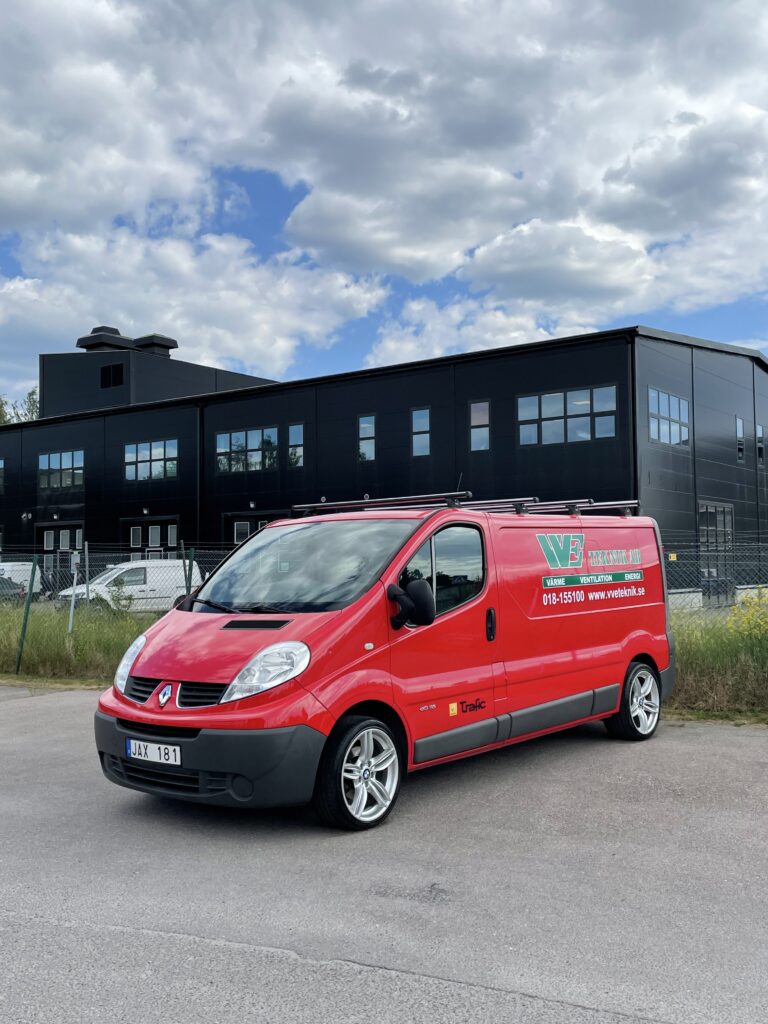 VVE Teknik's jobbarbil med en stor lokal i bakgrunden